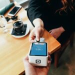 person holding credit card swipe machine